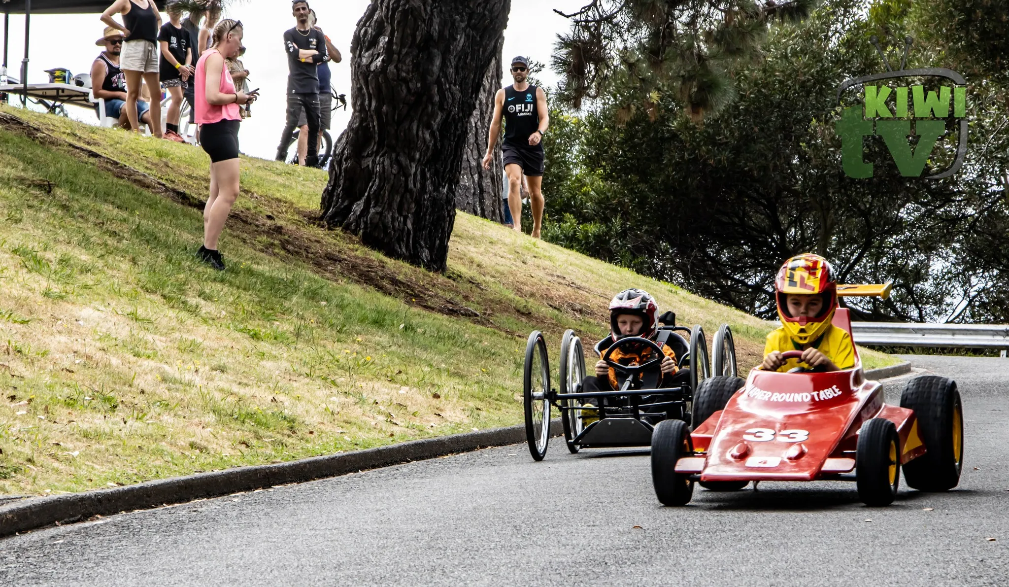 Kids posing with their custom-built kart in 2023 pits